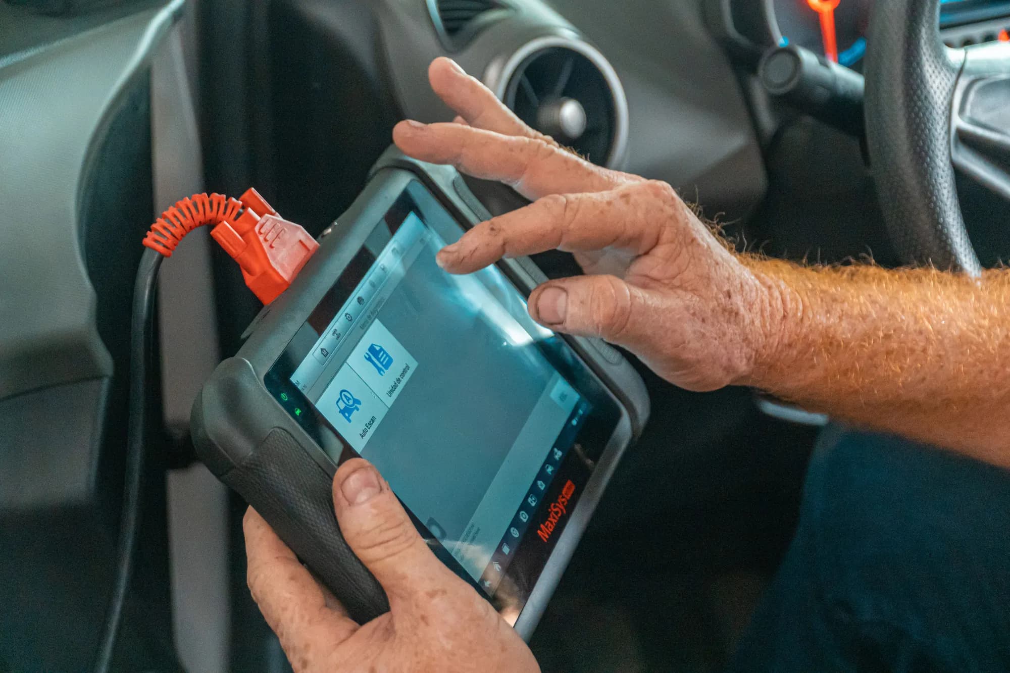 Diagnostic scan tool being used on a car